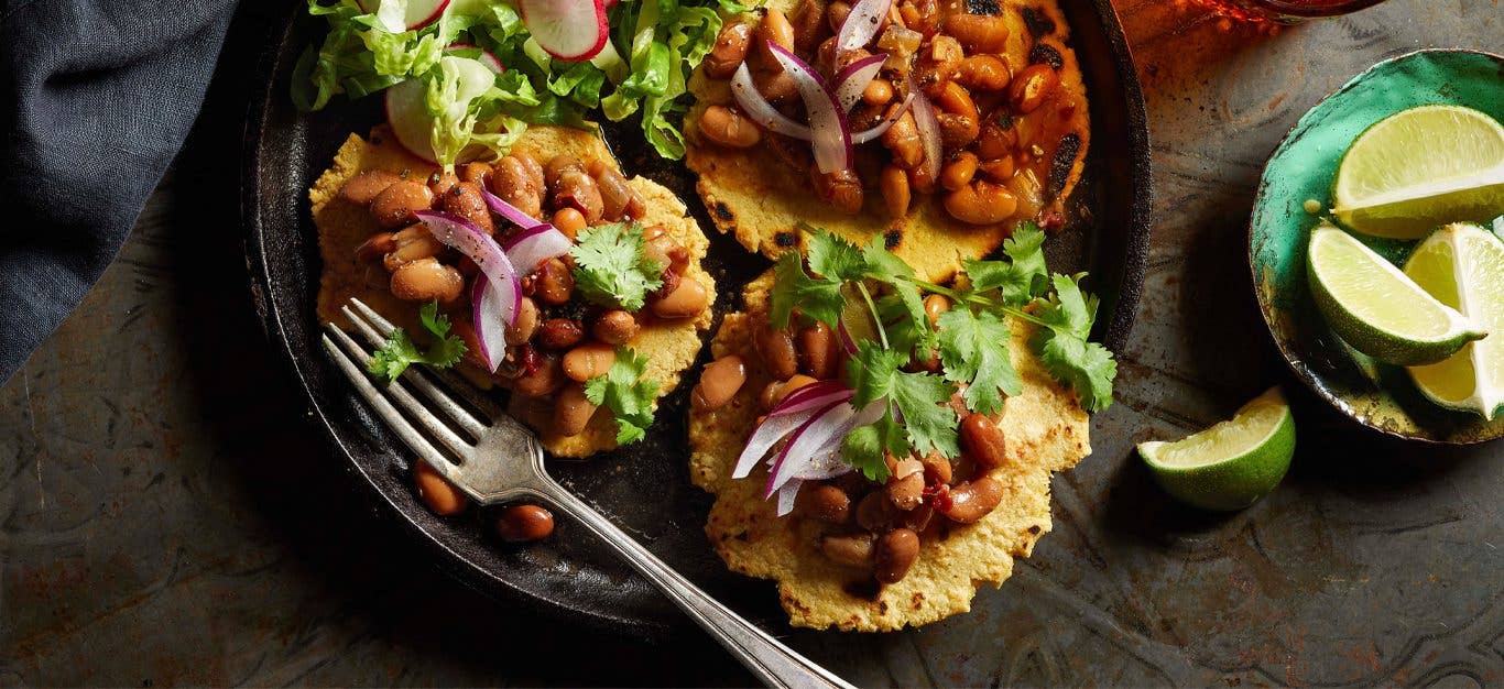 Vegan Bean Gorditas on a black plate with lime wedges