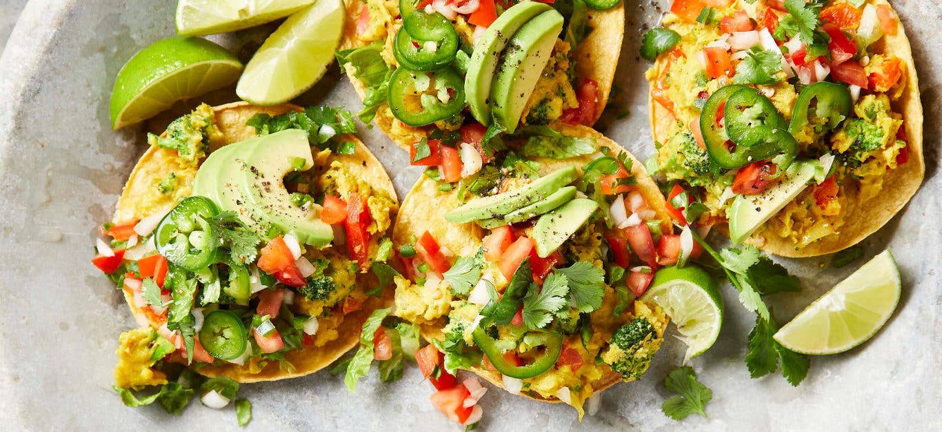 Breakfast Tostadas topped with salsa and lime wedges on a marble countertop