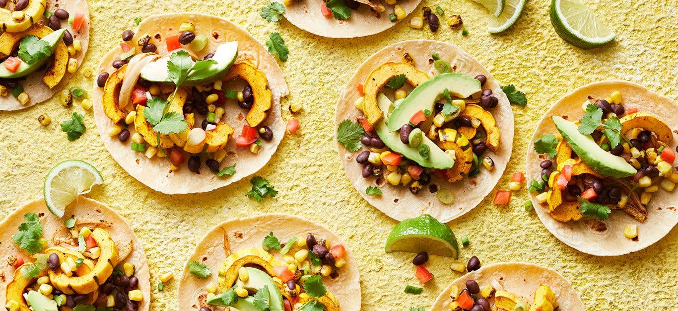 delicata squash tacos with avocado on a yellow surface