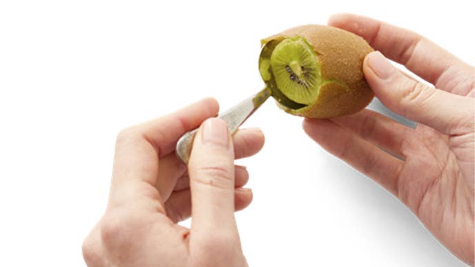 Kiwi with spoon peeling it