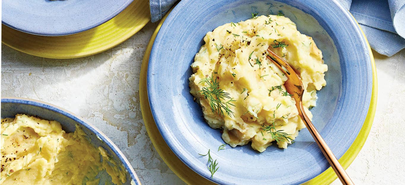 Lemon and Dill Mashed Potatoes in a blue bowl with a gold metal fork