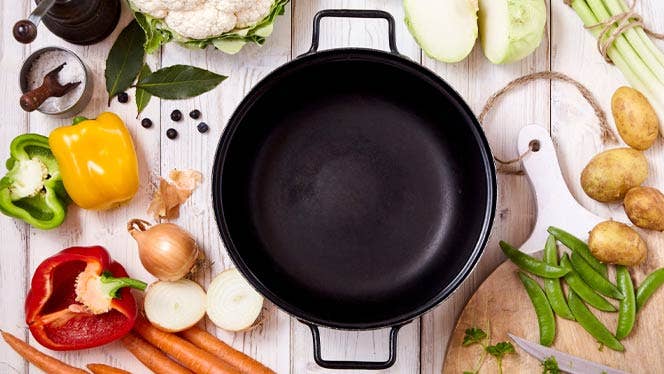 top down shot of cast iron pot surrounded by colorful veggies