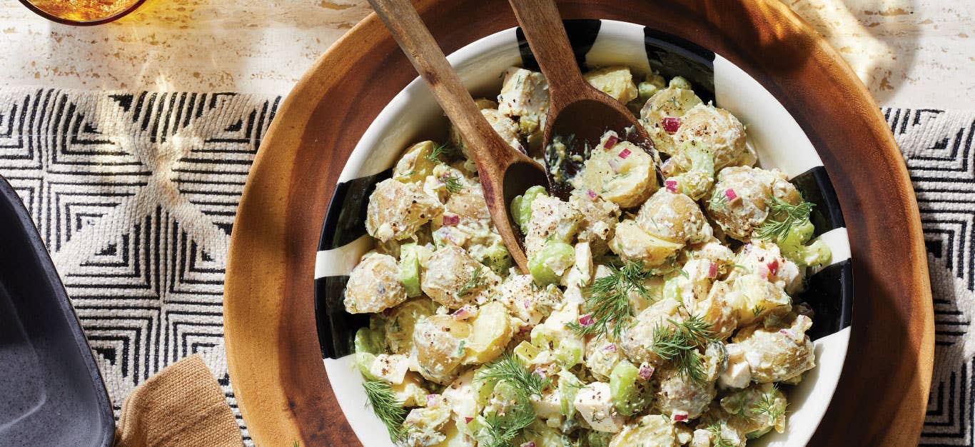 Old-Fashioned Potato Salad with Vegan Mayo in a wooden bowl with wooden serving spoons