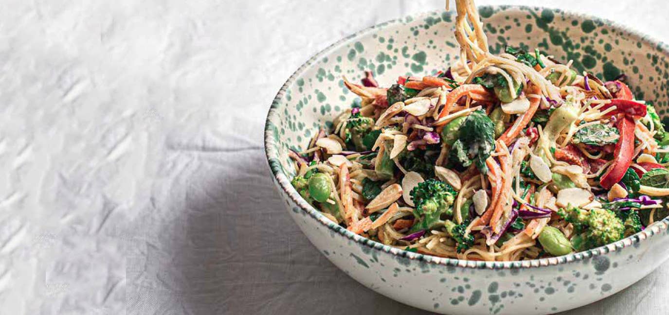 Saucy Vermicelli with Vegetables and Fresh Herbs in a speckled white ceramic bowl