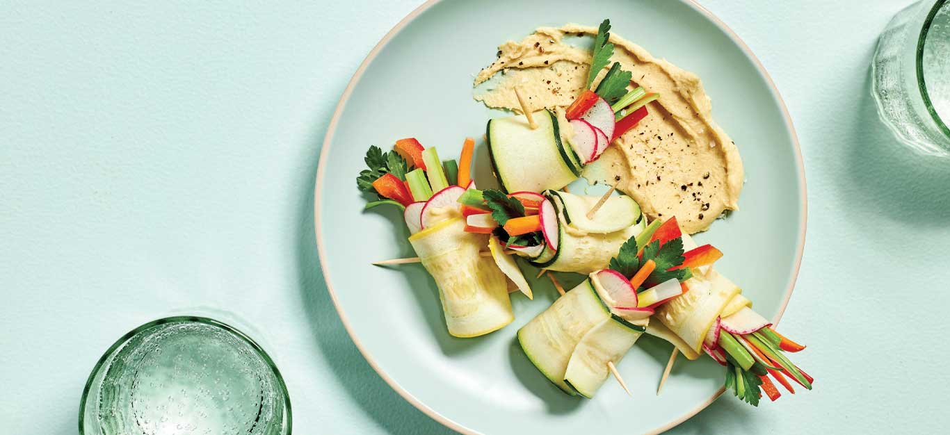 Summer Squash Roll-Ups on a light blue plate with clear water glasses