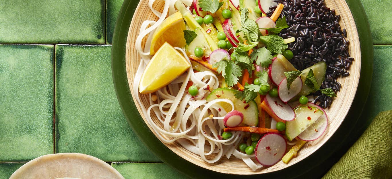 Refreshing Vietnamese Noodle Salad in a white bowl on a green tile background